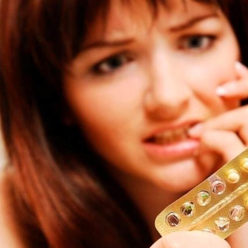 mulher preocupada segurando uma cartela de pílula anticoncepcional
