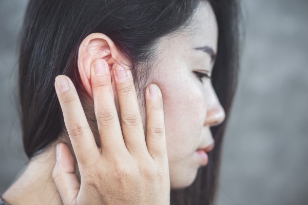 mulher com infecção no ouvido