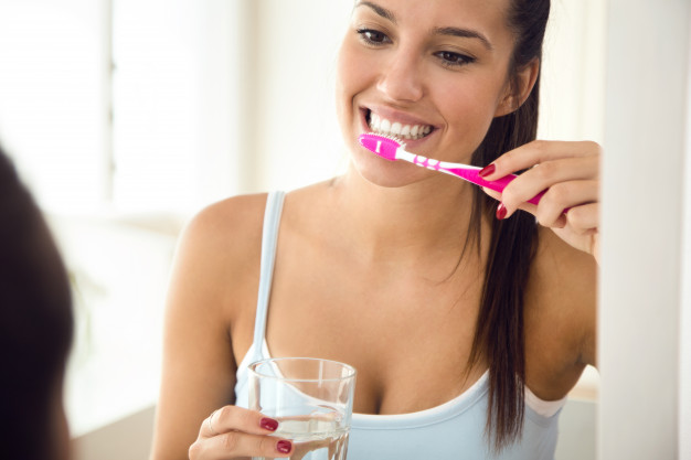 mulher escovando os dentes