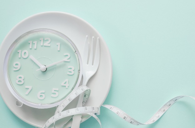 Relógio azul no prato branco funco azul e fitra métrica.