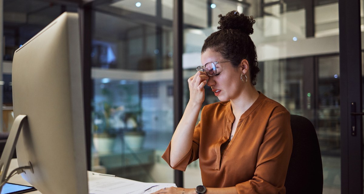 Mulher enfrentando burnout digital em seu trabalho, em um escritório